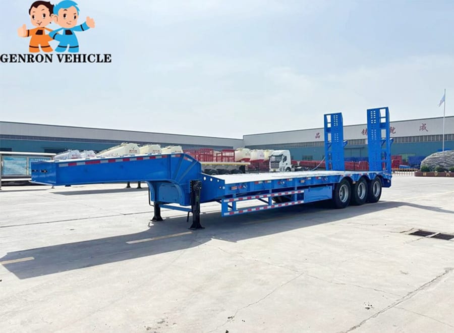 Blue low bed trailer with an open deck and rear loading ramps