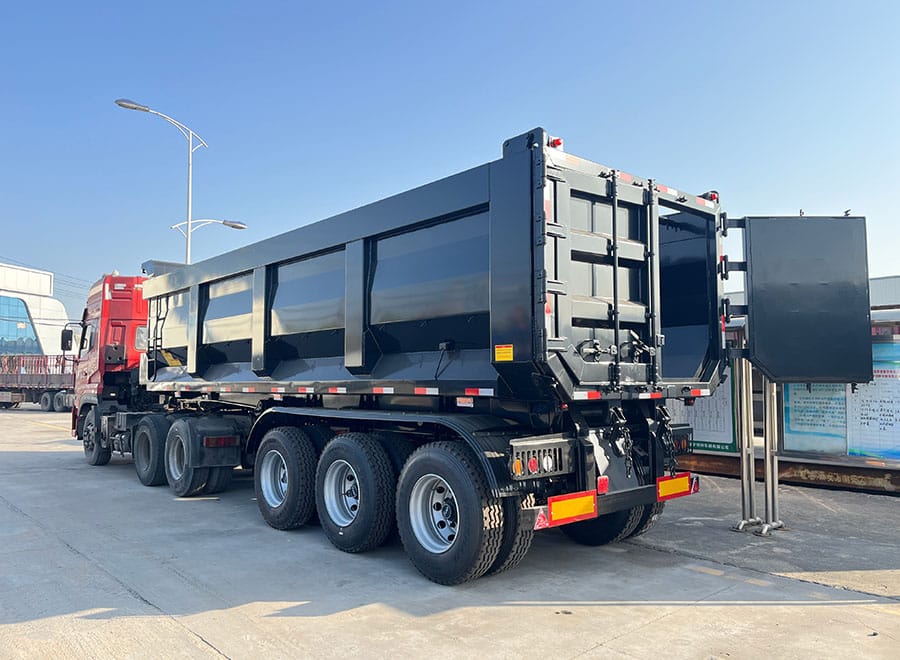 GENRON rear dump trailer coupled to a red tractor
