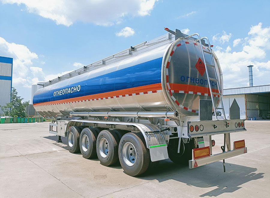 Polished fuel tank semi trailer with blue and orange side stripes