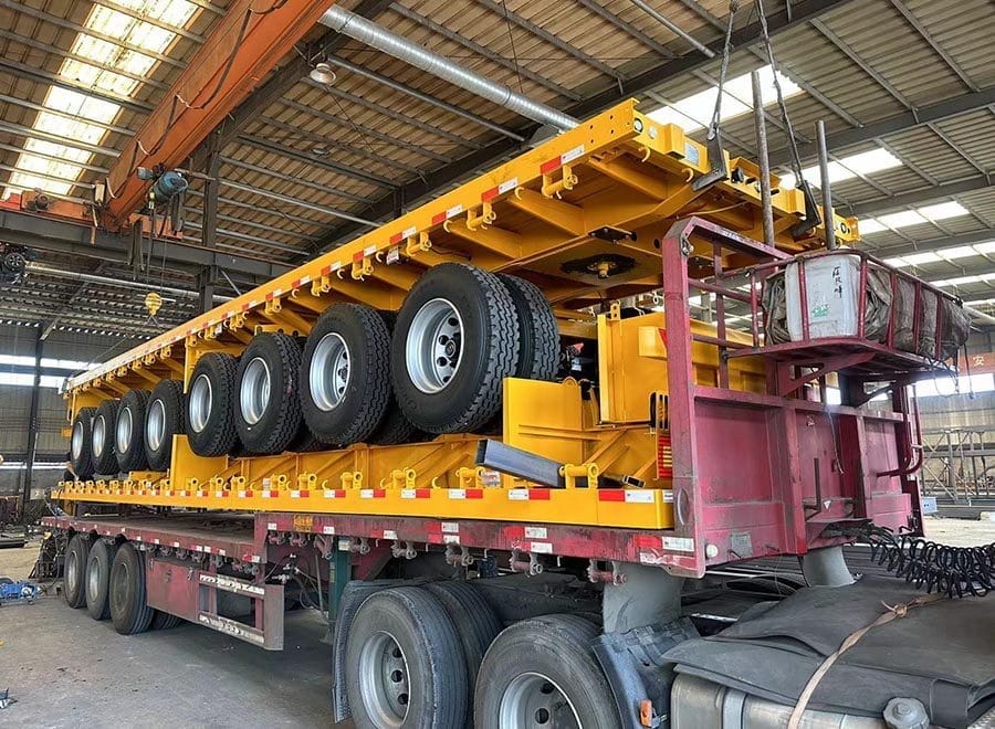 Yellow trailer frames and underbody components in a workshop
