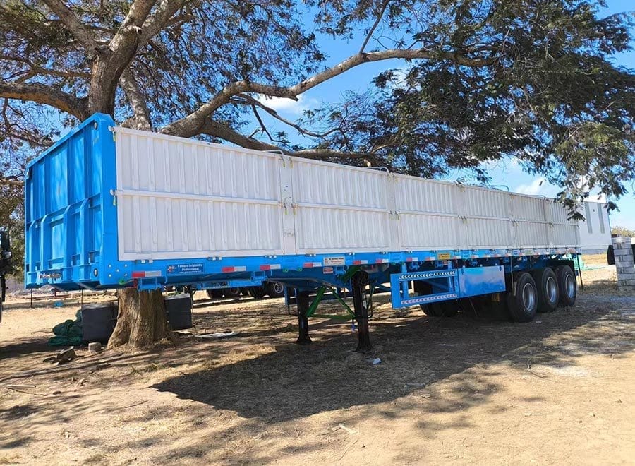 Blue dropside trailer with white side panels parked outdoors