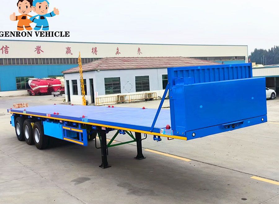 Blue flatbed semi trailer with a front headboard in the factory yard
