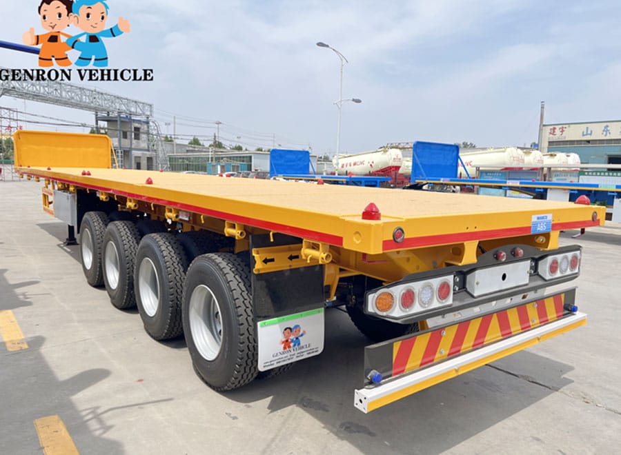 Yellow flatbed trailer viewed from the rear in the factory yard