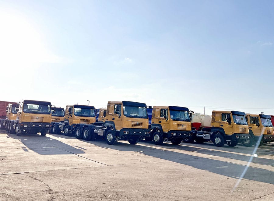 Yellow HOWO tractor trucks parked in a row in the yard